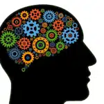 A black silhouette of a human head in profile, filled with numerous interlocking, colorful gears of various sizes, symbolizing cognitive processes and thinking.