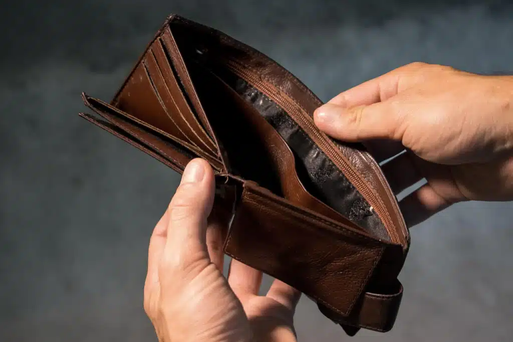 Stock photo of hands holding an open brown leather wallet that is visibly empty, symbolizing financial constraint or the need for budget-friendly options.