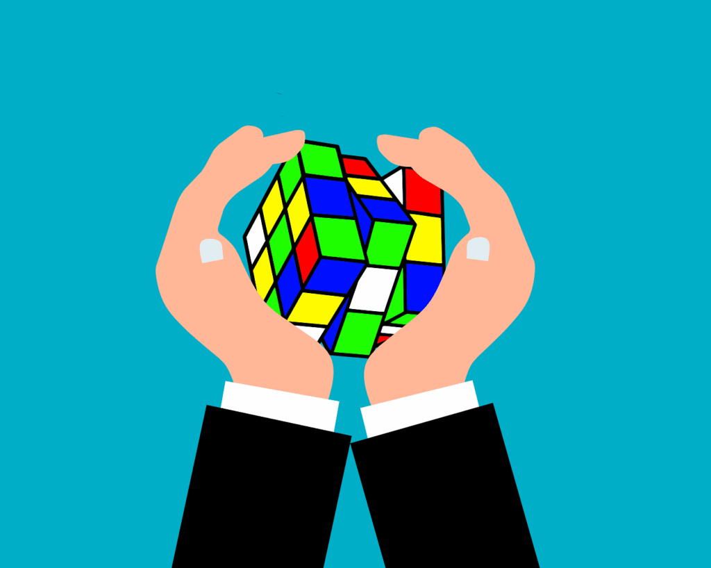 An illustration of two hands holding a partially solved colorful Rubik's Cube against a teal background, symbolizing the challenge and process of solving complex problems in speech therapy with a growth mindset.