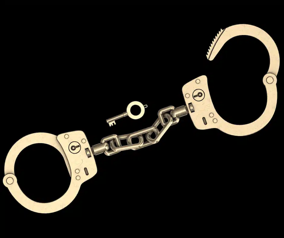A pair of shiny metal handcuffs with a small key lying next to them on a black background, symbolizing the financial constraints and feeling of being trapped by pension systems for teachers.