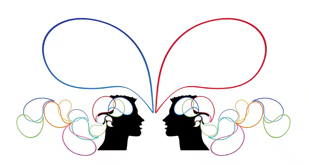 A black line illustration featuring two silhouetted human head profiles facing each other. Large, empty speech or thought bubbles emanate from their heads, connected by multiple colorful, swirling lines, symbolizing communication or interconnected thoughts.