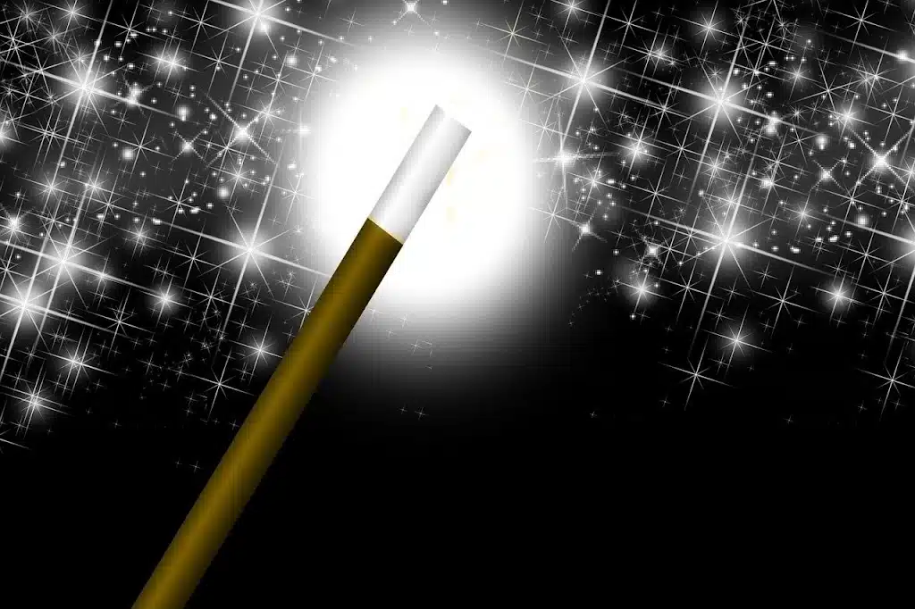 A gold and white magic wand glowing brightly against a dark background filled with sparkling stars, symbolizing the magic of short stories in speech therapy.