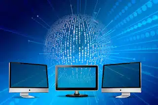 Three modern computer monitors with blank screens, digitally connected to a glowing blue global network sphere covered in white binary code, set against a blue background with radiating lines.