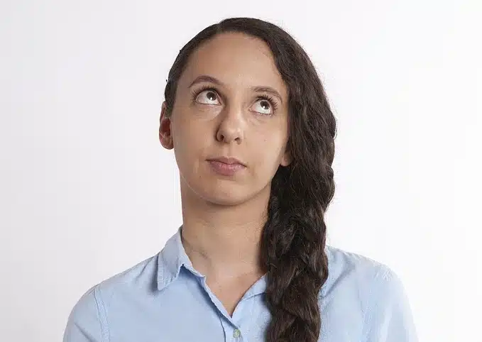 Young woman with long dark hair looking up with an exasperated expression, reflecting the challenge of low student interest and its impact on therapy progress.