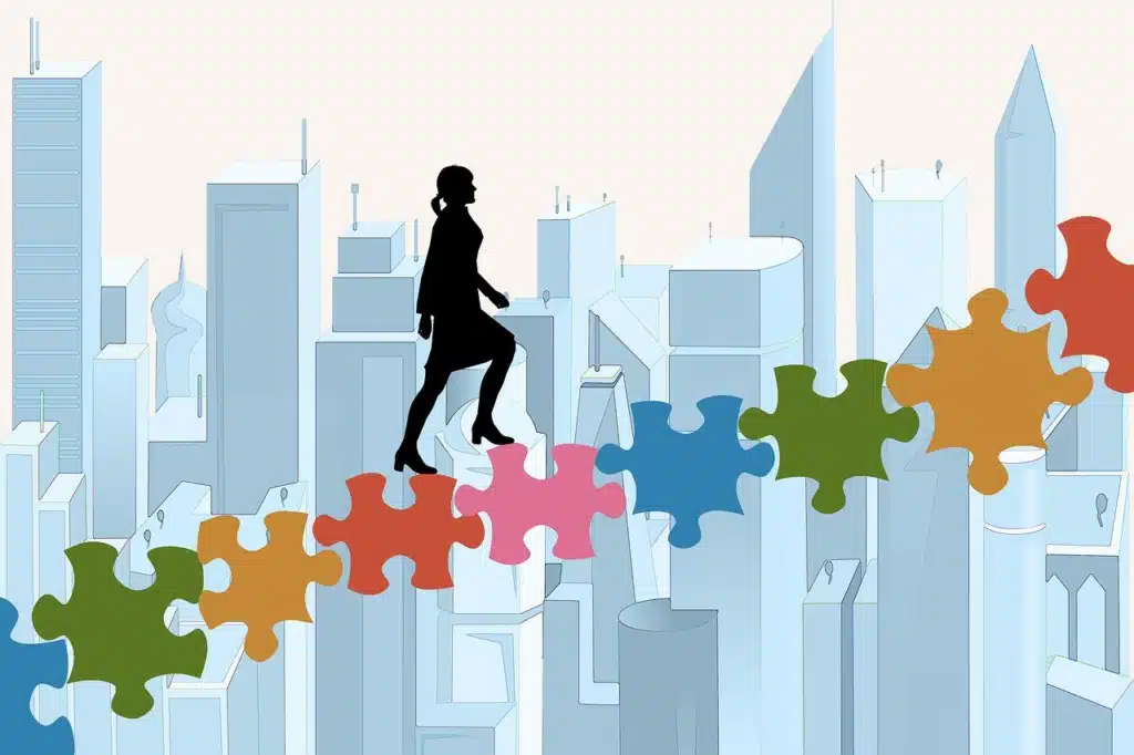 Silhouette of a woman walking on a bridge made of colorful puzzle pieces leading towards a city skyline, symbolizing progress and building foundational skills. 