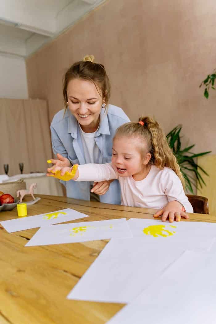 hero-gallery-02 A mother and daughter enjoy a creative finger painting session together indoors, an optimal time for developing speech and language skills.